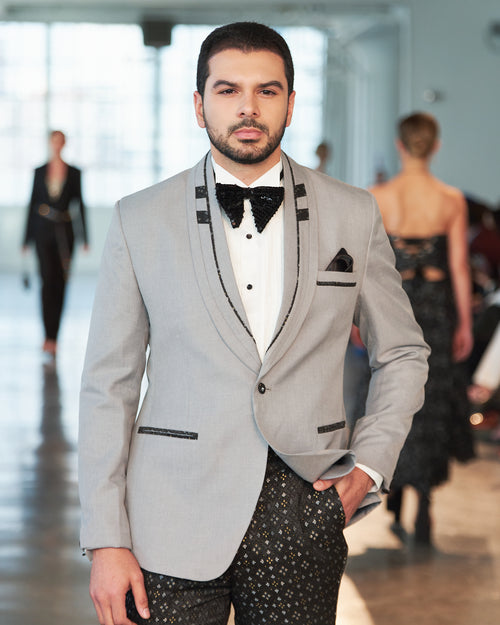 Stylish grey tuxedo jacket with custom lapel with black, silver and gold pattern trousers